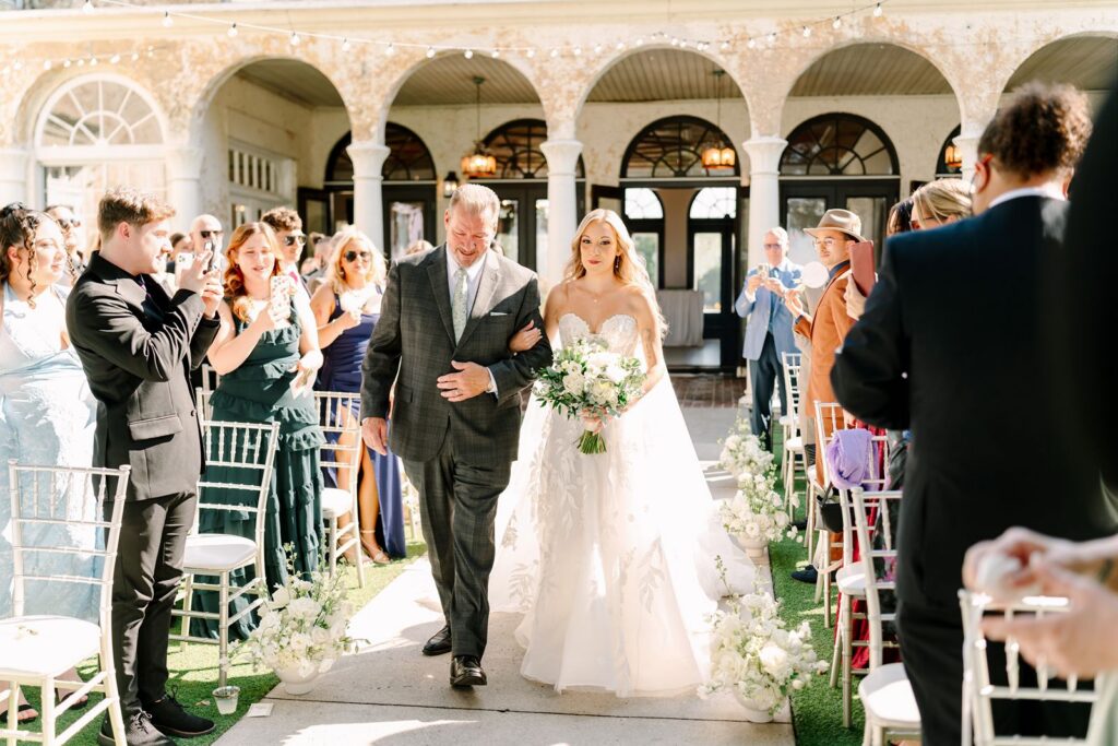 Bride and dad coming down the aisle at Bella Cosa Wedding Venue